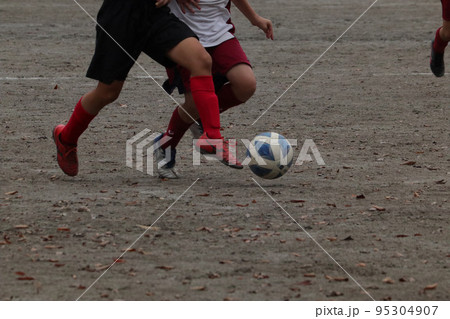 サッカーでボールを追いかける少年 95304907