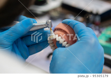 Dental technician working with dental prosthetics - close up view 95305179