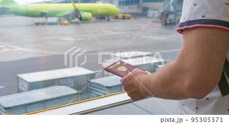 Male hands holding passport with plane tickets, top view. 95305371