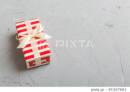Wrapped christmas or other holiday handmade present in paper with colored ribbon. Present box, decoration of gift on table, top view with copy space Wrapped christmas or other holiday handmade present in paper with colored ribbon. Present box, decoration of gift on table, top view with copy space 95307661