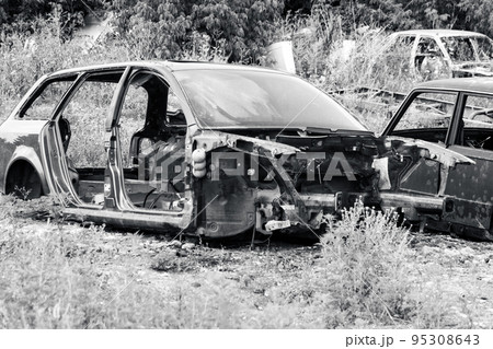 Metal rusty car body parts abandoned in grayscale Metal rusty car body parts abandoned in grayscale 95308643