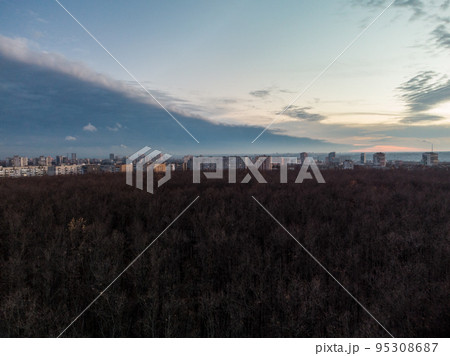 Aerial evening blue cloudy city near autumn forest 95308687