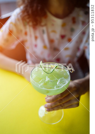 female drink green alcohol fruit cocktail with cucumber, lime, kiwi, tarragon female drink green alcohol fruit cocktail with cucumber, lime, kiwi, tarragon 95311832
