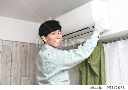 家庭用エアコンの前にいる男性作業員 家庭用エアコンの前にいる男性作業員 95312068