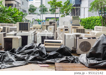 A lot of Air conditioners stacked up in a pile to disposal at recycling garbage dump. Stack of old and dirty air conditioners defective and discarded for recycling process industry. Old appliances. 95312142