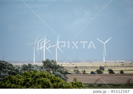 広々としたフィールの中に立つ大きいローターの付いた風力発電機 95312587