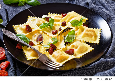 italian ravioli with chorizo ricotta filling on plate 95313032