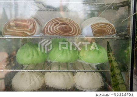 Healthy vegan steamed red bean buns or Dou Sha Bao inside a glass display shelf Healthy vegan steamed red bean buns or Dou Sha Bao inside a glass display shelf 95313453