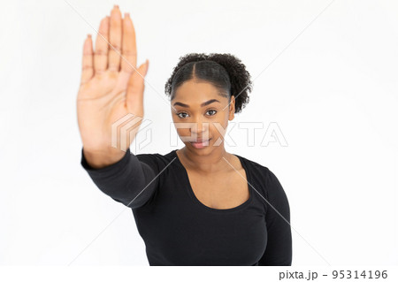 Portrait of confident young woman making warning gesture 95314196
