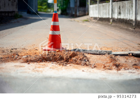 traffic cone on damaged road surface traffic cone on damaged road surface 95314273
