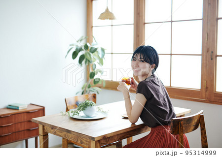 お茶中にこちらへ満面の笑みを向けるショートカット女性の写真 お茶中にこちらへ満面の笑みを向けるショートカット女性の写真 95314999