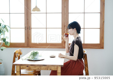 清潔な部屋でお茶をするショートカット女性の写真 95315005