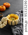 Pumpkin cream soup served in a squash with seeds 95315290