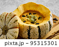 Pumpkin cream soup served in a squash with seeds 95315301