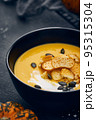 Pumpkin cream soup with croutons on dark background 95315304
