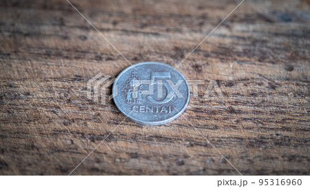 Five Lithuanian cents coin isolated on wooden background. Five Lithuanian cents coin isolated on wooden background. 95316960
