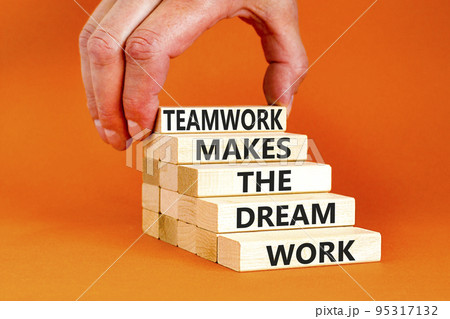Teamwork makes dream work symbol. Concept words Teamwork makes the dream work on wooden blocks on beautiful orange background. Businessman hand. Business Teamwork makes dream work concept. Copy space. Teamwork makes dream work symbol. Concept words Teamwork makes the dream work on wooden blocks on beautiful orange background. Businessman hand. Business Teamwork makes dream work concept. Copy space. 95317132