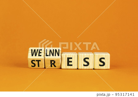 Stress or wellness symbol. Concept words Stress or Wellness on wooden cubes. Beautiful orange table orange background. Business stress or wellness concept. Copy space. 95317141