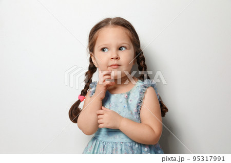 Cute little girl on light grey background Cute little girl on light grey background 95317991