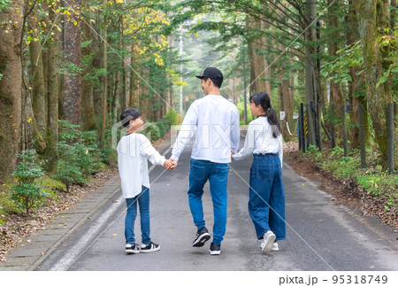 手をつないで歩いている親子コーデの3人家族 95318749