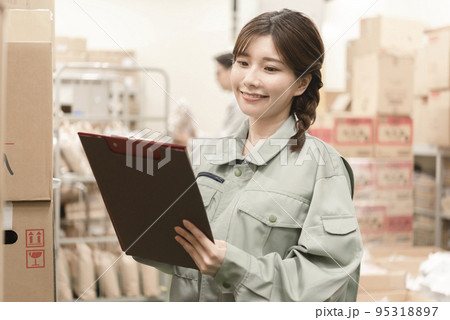 在庫を数える倉庫作業員の女性 95318897