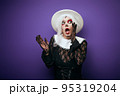 Scared whispering woman with grey hair in Halloween costume 95319204