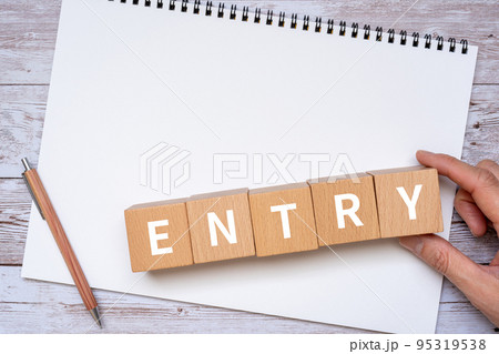 ENTRYと書かれたブロック、ノート、ペン、手 95319538
