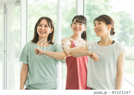 スポーツジムで肘タッチをするスポーツウェアのアジア人の女性達 95323147