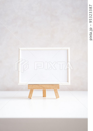 Empty picture frame mock up in minimalist interior on white table. 95323387