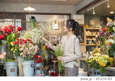 花屋で花を選ぶ女性 花屋で花を選ぶ女性 95324785