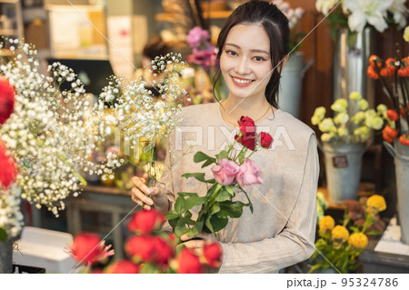 花屋で花を選ぶ女性 95324786