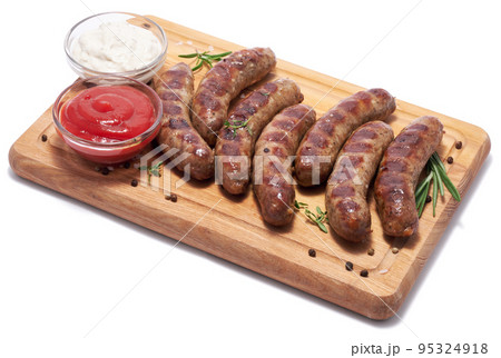 Grilled sausages on wooden cutting board isolated on white background Grilled sausages on wooden cutting board isolated on white background 95324918