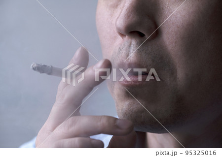 タバコを吸う男性の口元 95325016