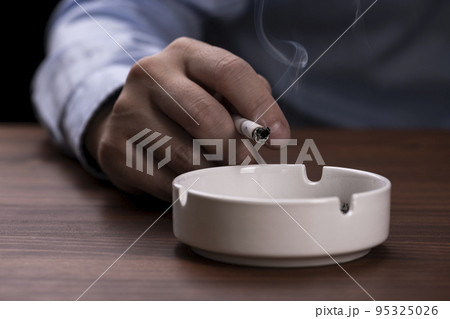 喫煙する男性が手に持っているタバコ 喫煙する男性が手に持っているタバコ 95325026