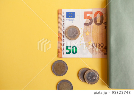 Fifty euro banknotes next to a notebook on a yellow background, Expense and budget planning. Cash paper currency, payment, earnings and savings, the concept of money and finance 95325748