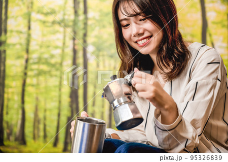 グランピング キャンプ場で朝のコーヒーを準備する若い女性 グランピング キャンプ場で朝のコーヒーを準備する若い女性 95326839