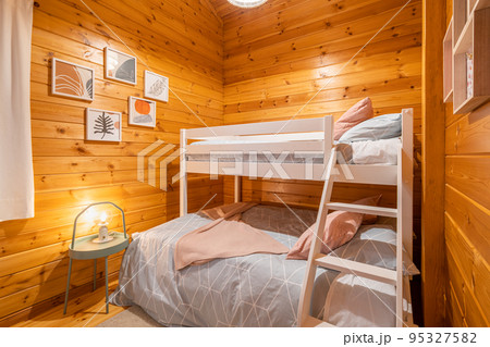 Children bedroom with bunk bed and wooden walls. Cozy and comfortable cottage interior. 95327582