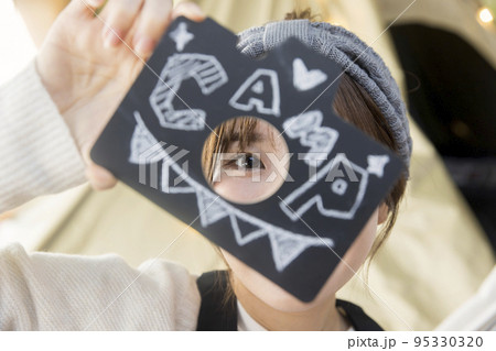 ハンモックに座って文字を見せる若い女性　　家キャン おうちキャンプ　キャンプイメージ 95330320