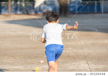 学校の校庭を走っている小学生の男の子 95330448