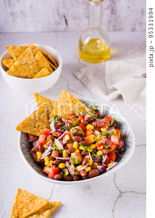 Homemade cowboy caviar traditional mexican vegetable salad and nachos in a bowl. Vertical view 95331994