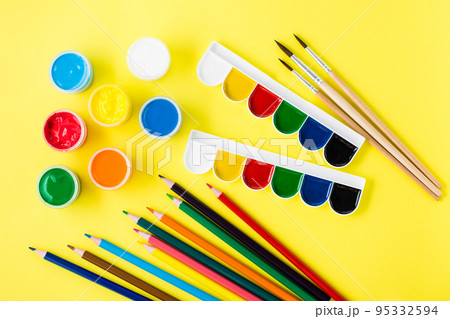 Painting tools. Gouache, watercolors, pencils and brushes on a yellow background. Creative leisure Painting tools. Gouache, watercolors, pencils and brushes on a yellow background. Creative leisure 95332594