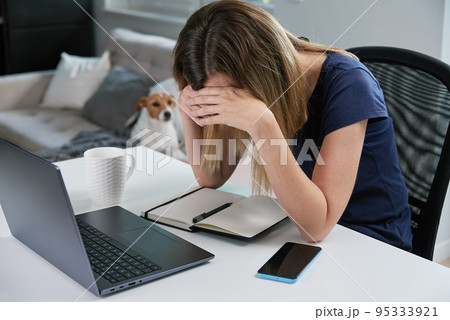 Thirty years old tired woman working late remotely at home office, using computer, remote work burnout 95333921