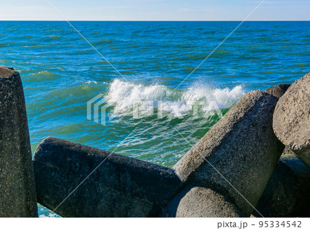 Wave breaker along the sea shore on the sand beach. 95334542
