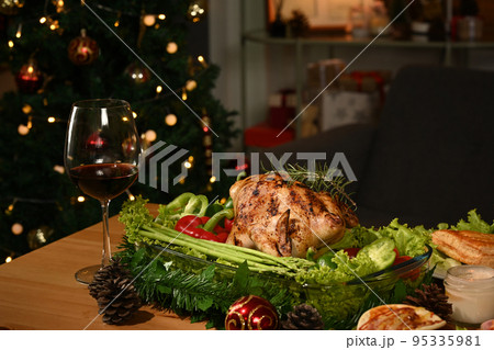 Image of thanksgiving table with baked turkey, glass of red wine and candle. Thanksgiving celebration traditional dinner concept Image of thanksgiving table with baked turkey, glass of red wine and candle. Thanksgiving celebration traditional dinner concept 95335981