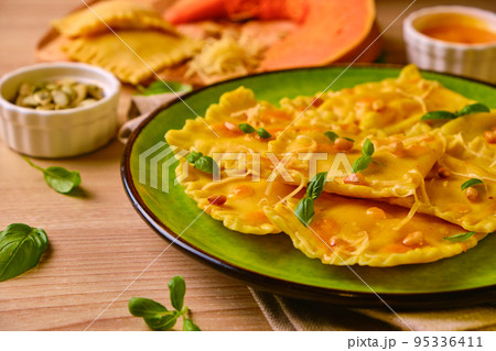 Homemade Pumpkin Ravioli with ricotta cheese served basil 95336411