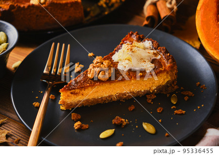 Homemade pumpkin cheesecake decorated with whipped cream 95336455