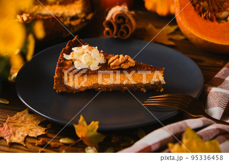 Homemade pumpkin cheesecake decorated with whipped cream Homemade pumpkin cheesecake decorated with whipped cream 95336458