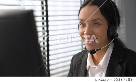 Competent female operator working on computer and while talking with clients. Competent female operator working on computer and while talking with clients. 95337288