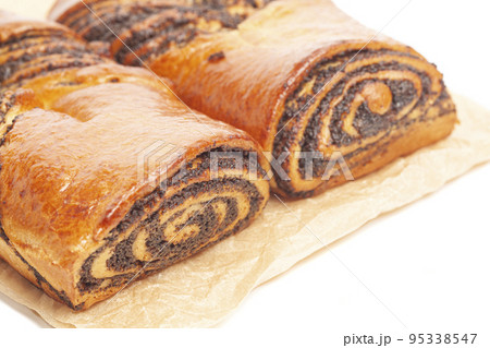 poppy seed strudel on a brown baking paper isolated on white poppy seed strudel on a brown baking paper isolated on white 95338547