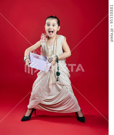 little black-haired fashionista in high-heeled shoes. funny photo shoot in the studio on a red background little black-haired fashionista in high-heeled shoes. funny photo shoot in the studio on a red background 95338881